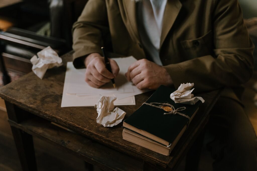 Author writing a manuscript at a wooden desk